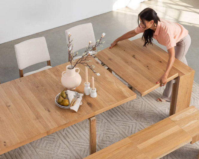 Une femme pose une rallonge sur une grande table